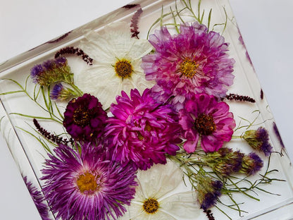 purple and white wedding flowers preserved in resin as coasters and ring holders