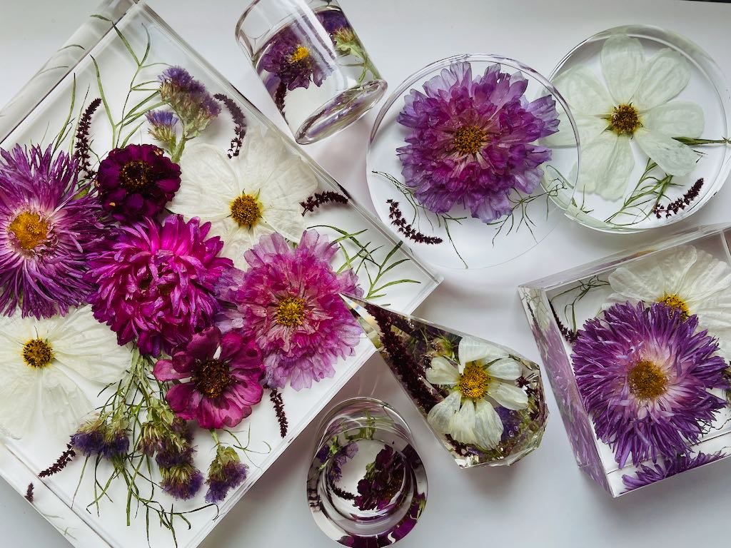 purple and white wedding flowers preserved in resin as coasters and ring holders